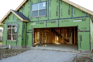 home exterior with garage open showing framing during construction
